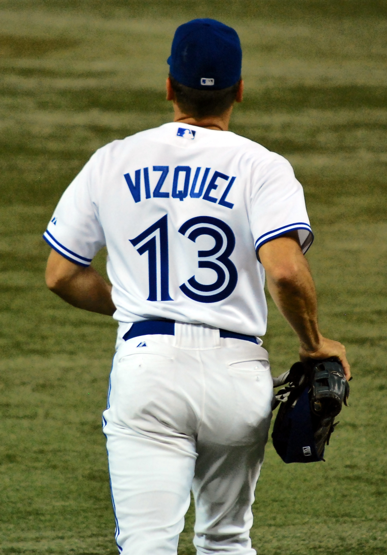 a baseball player standing on a field holding a glove