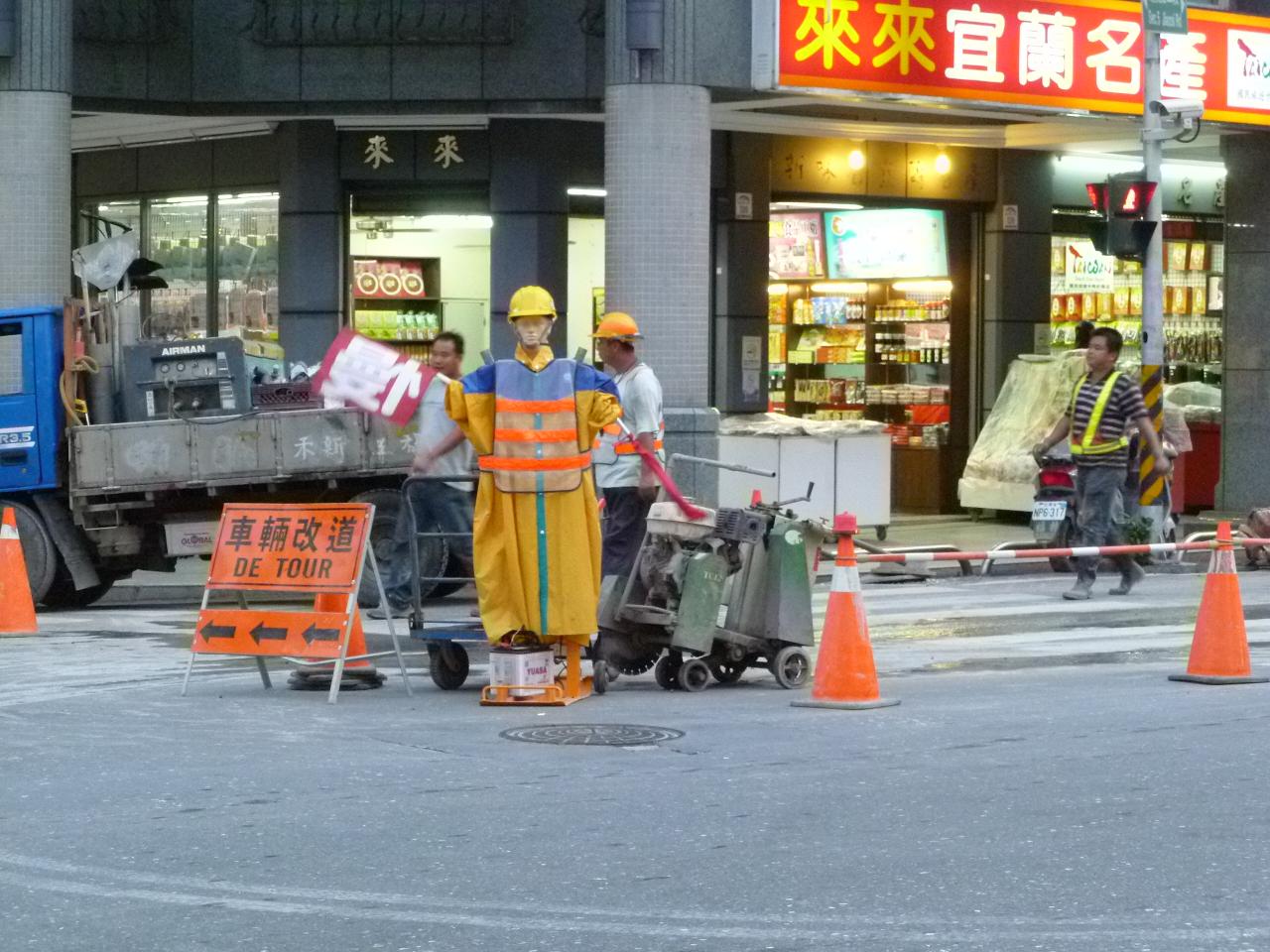 construction workers are on the sidewalk in front of buildings