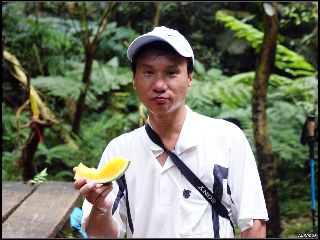 a man with cameras holding a yellow banana