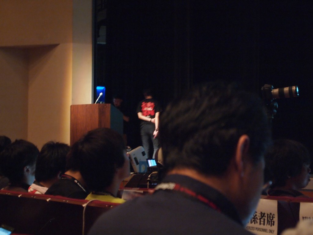 a woman standing at the front of a lecture hall