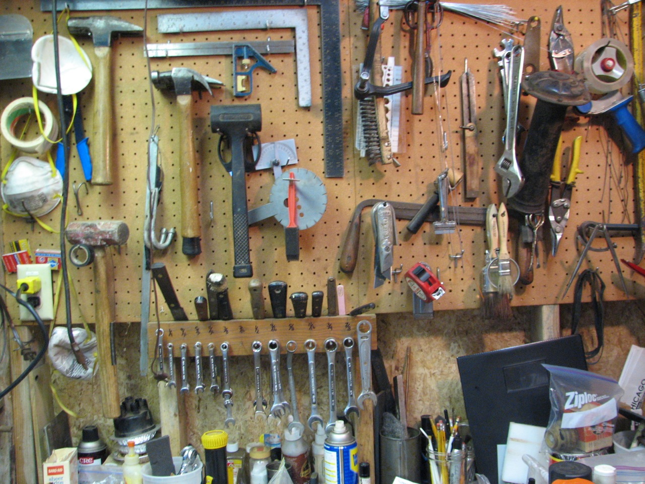 an organized garage wall with tools hanging on it