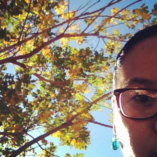 a man is posing in front of trees with glasses