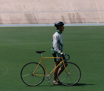 a man with a yellow bicycle in the grass