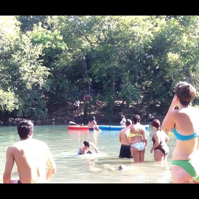 a bunch of people in the water near a lake