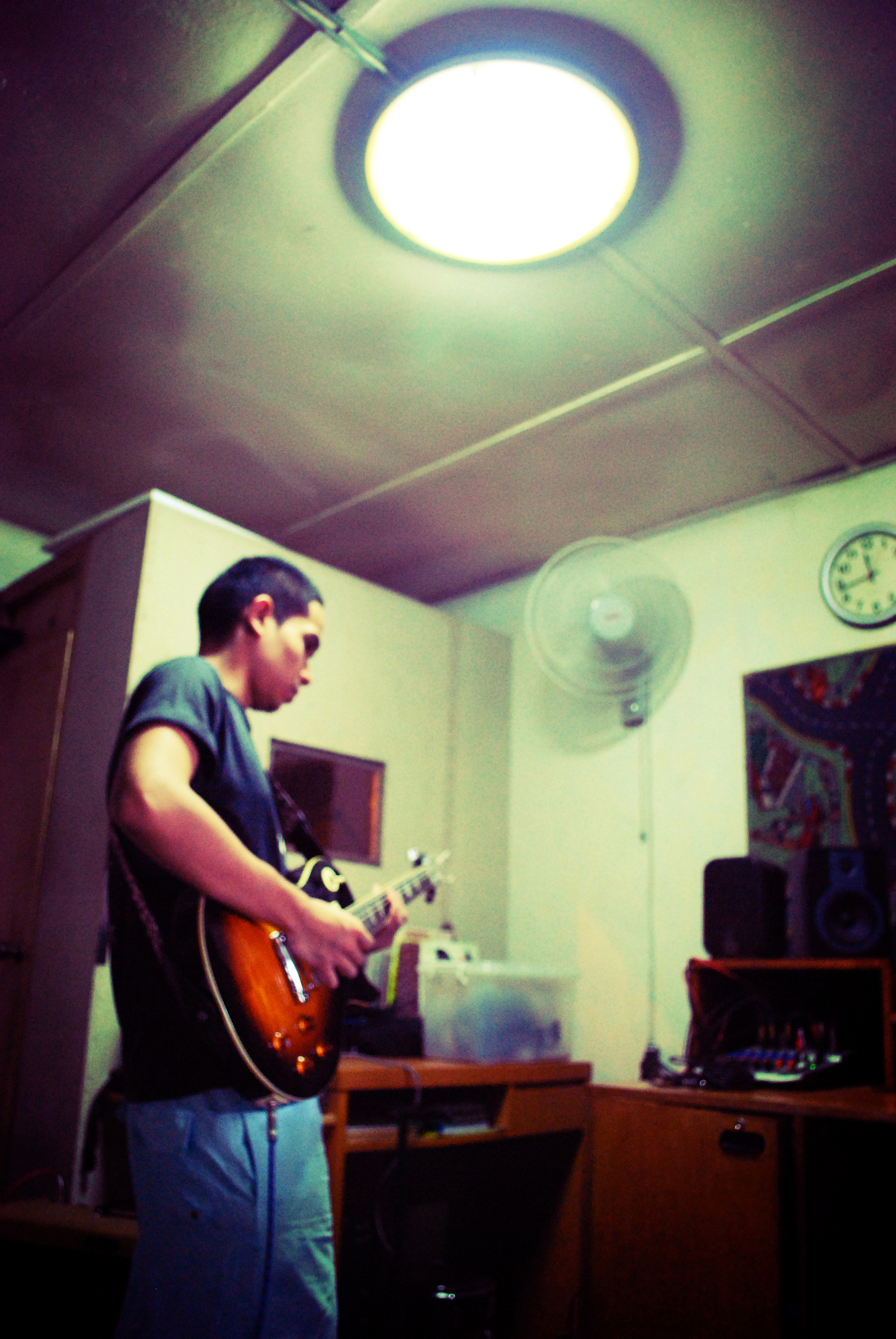 man standing in a room playing his guitar