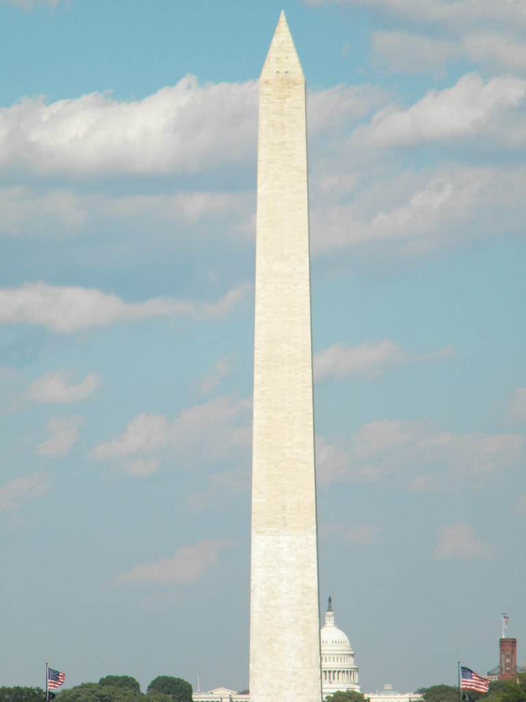 a view of the washington monument with trees in front of it