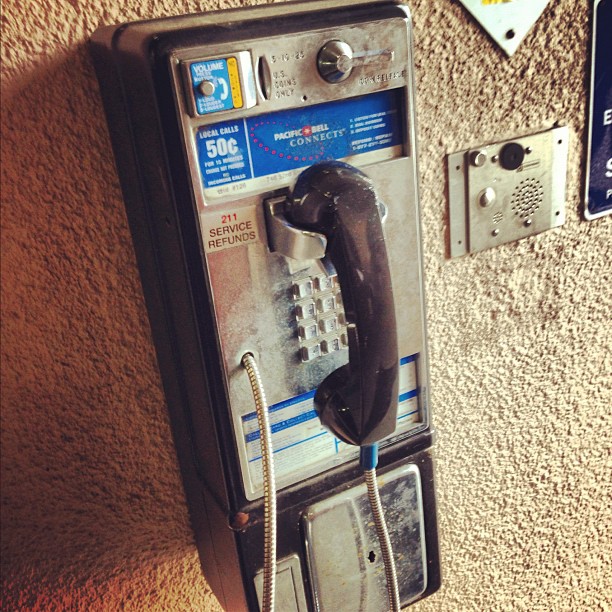 an old - fashioned phone and a telephone sign on a wall