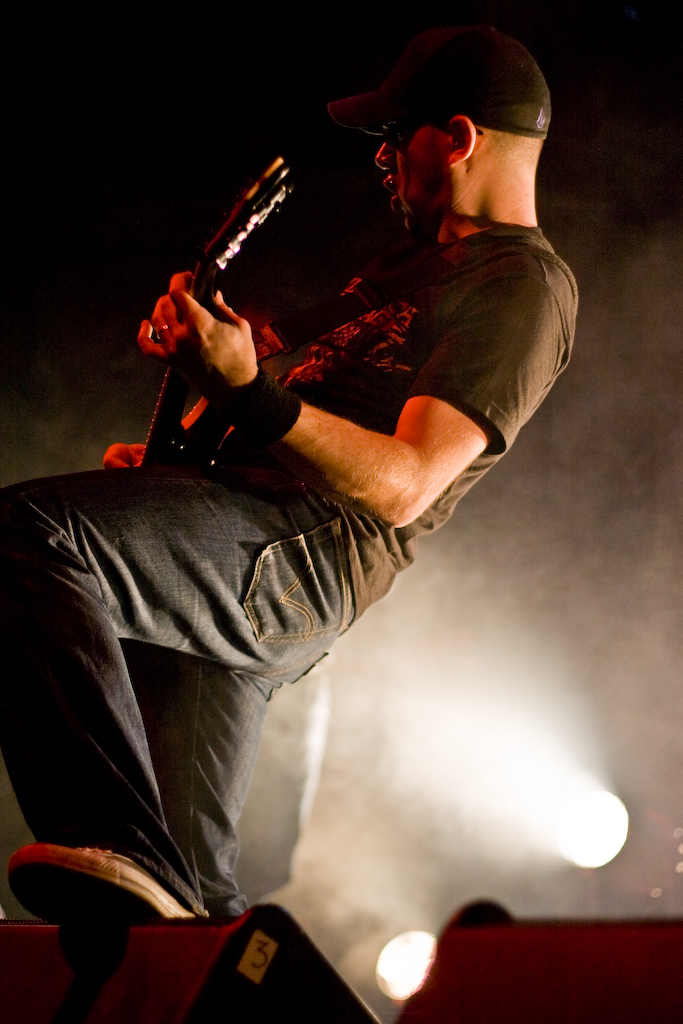 a man in black shirt and jeans playing guitar