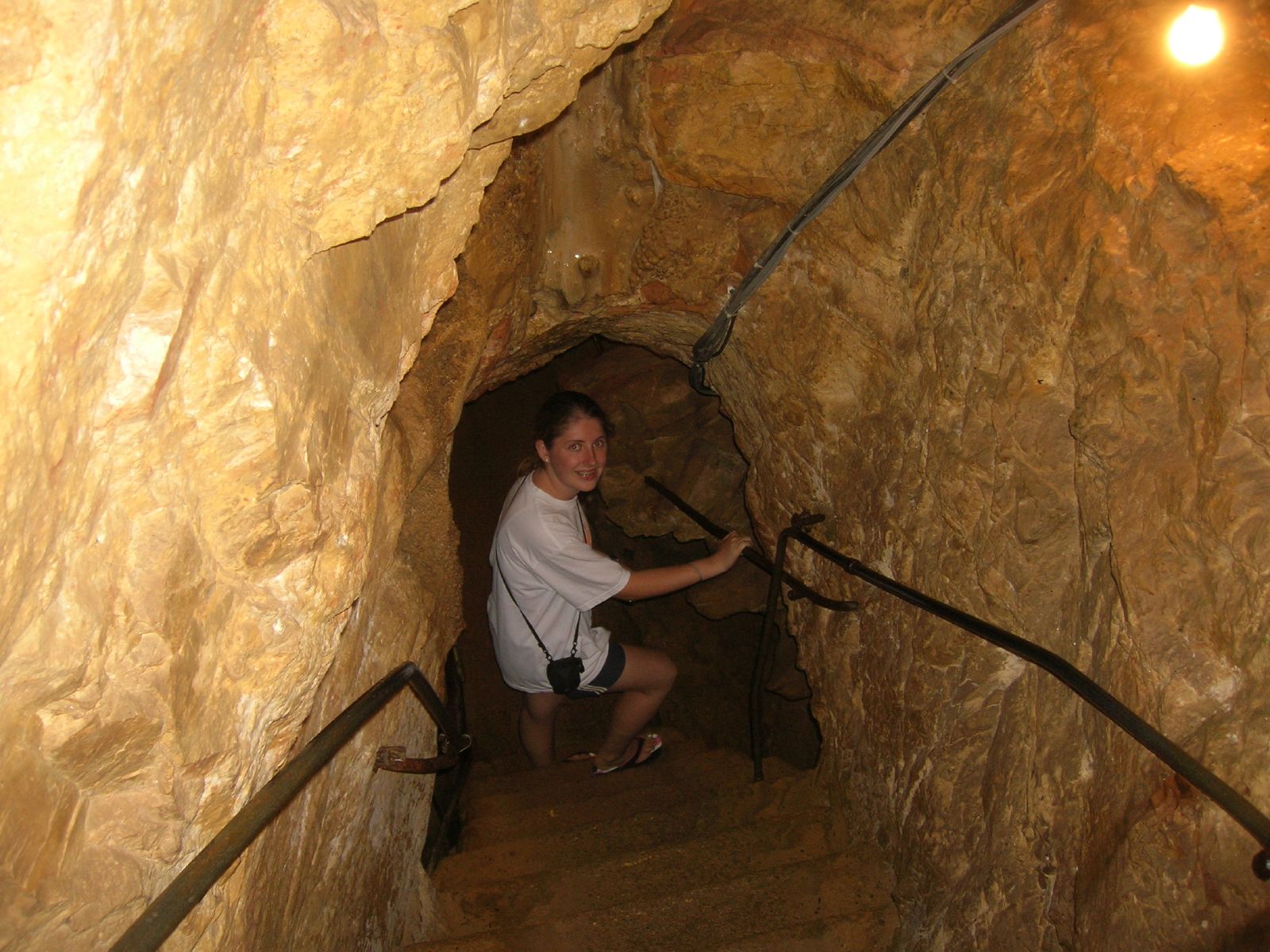 a woman is sitting down in a small tunnel