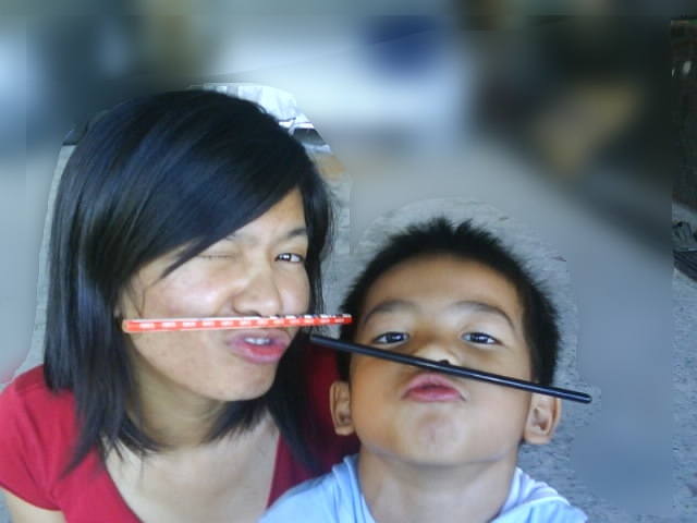 a woman and a child with their mouths open while holding orange straws