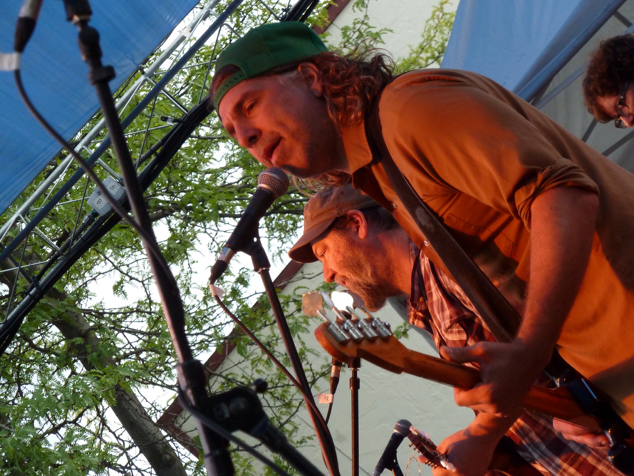 the man is singing into a microphone while holding onto a bass