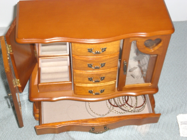 a small cabinet with drawers and a mirror