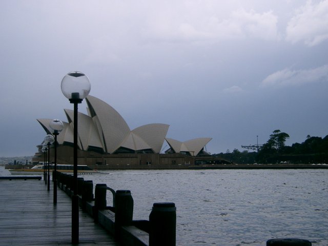 the view from a dock shows a large, white building near water