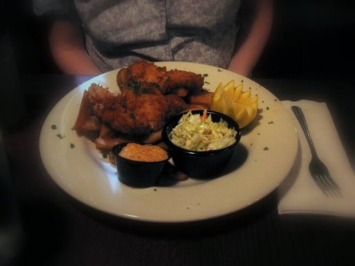 a white plate filled with chicken wings, cole slaw and fries