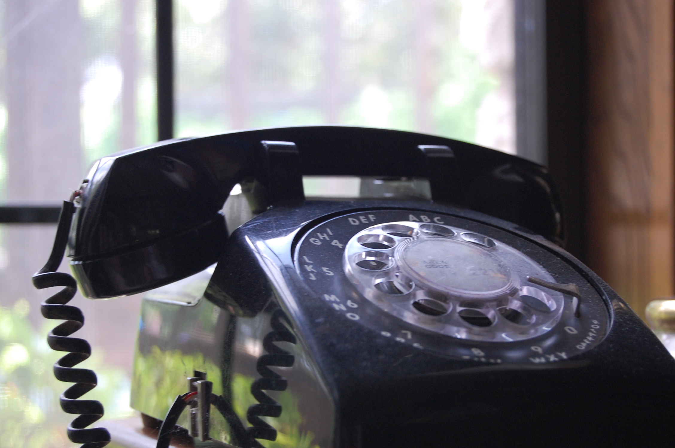 an old - fashioned phone stands in front of a window