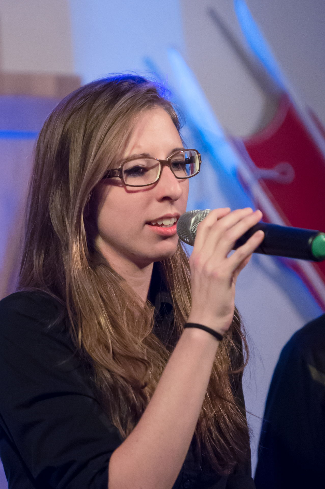 a woman holding up a microphone to sing