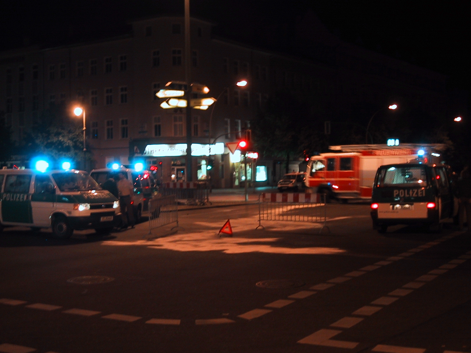 two emergency vehicles parked outside of a building at night