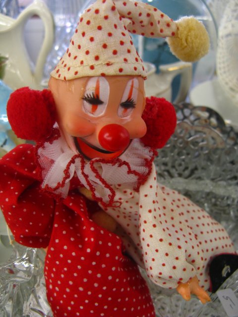 a toy clown wearing a polka dotted hat and dress
