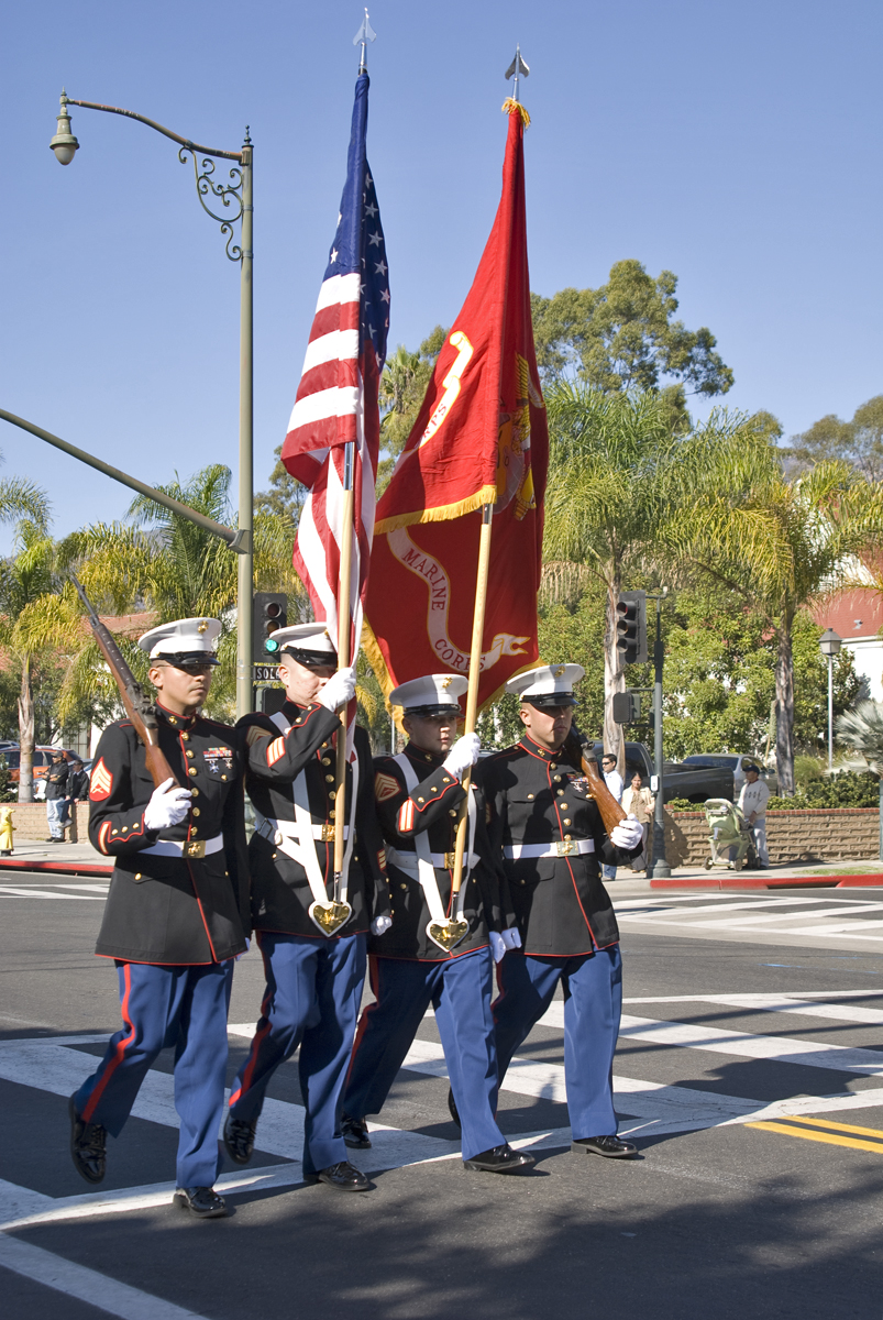 three military people holding american flags and banners