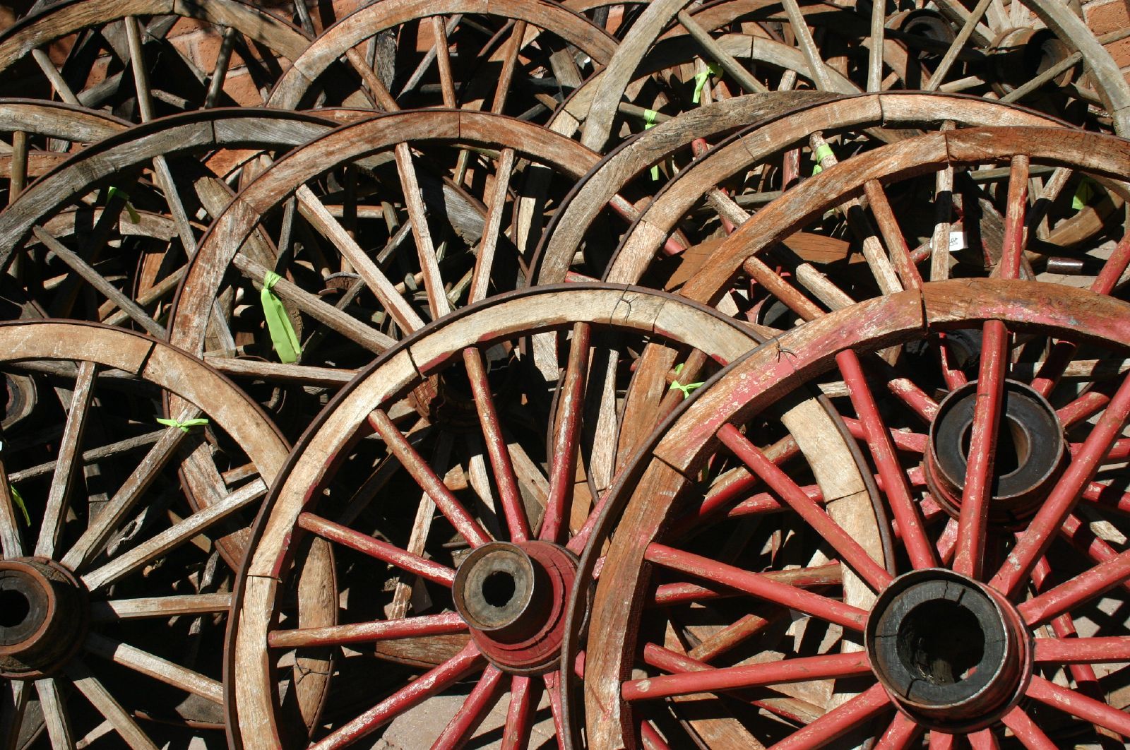 red wheels on grass being held up by wooden spokes