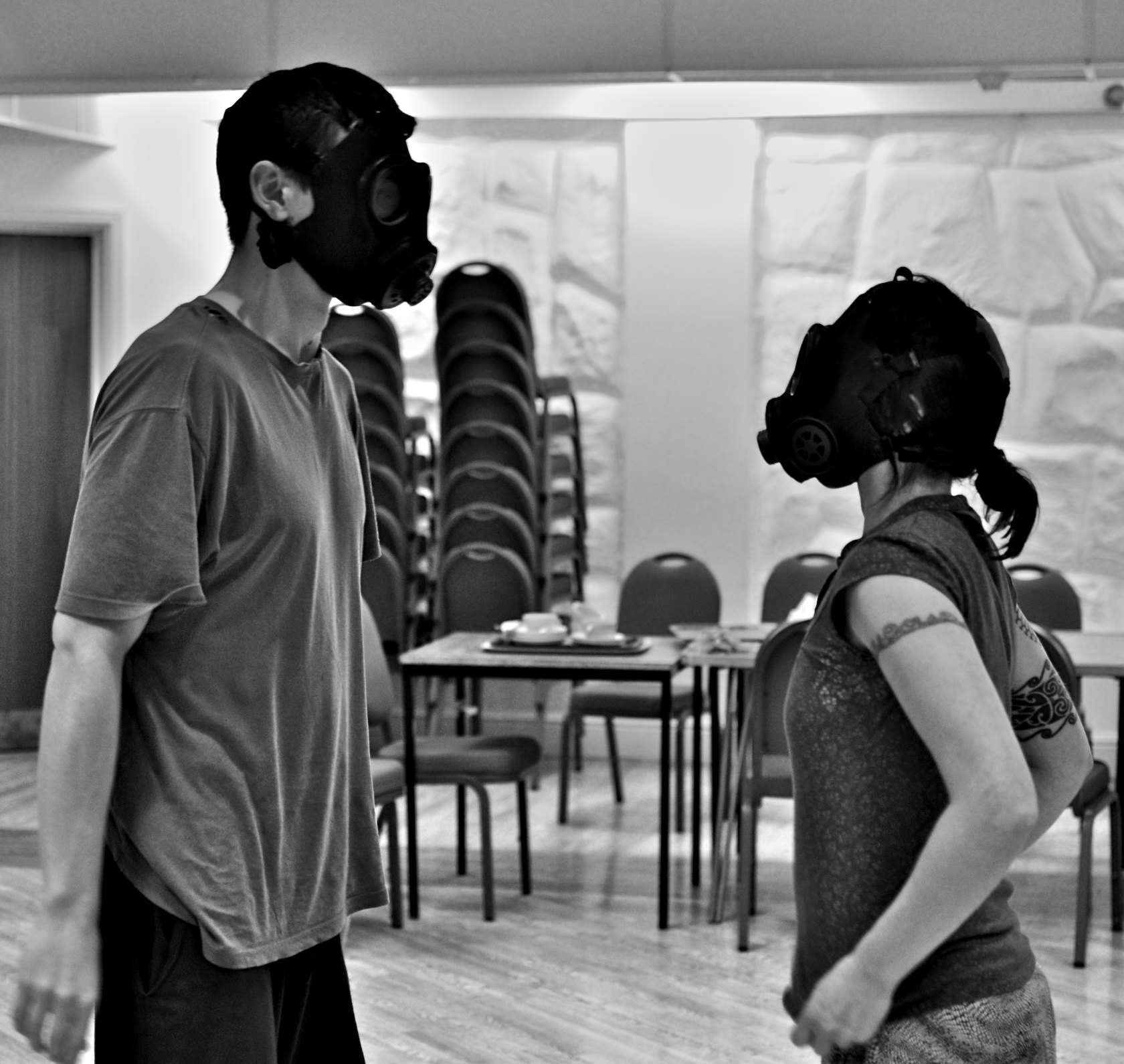 a woman with gas mask and man standing in a room