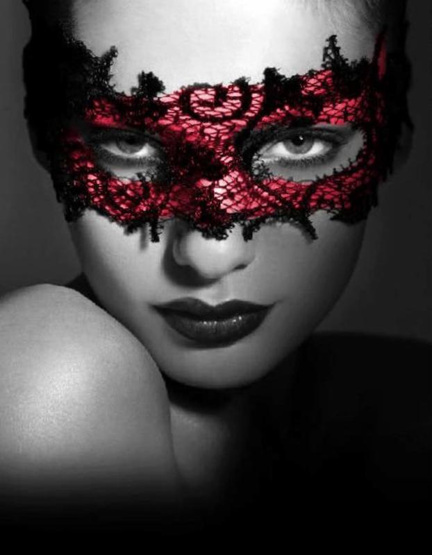 a woman wearing a black and red lace mask