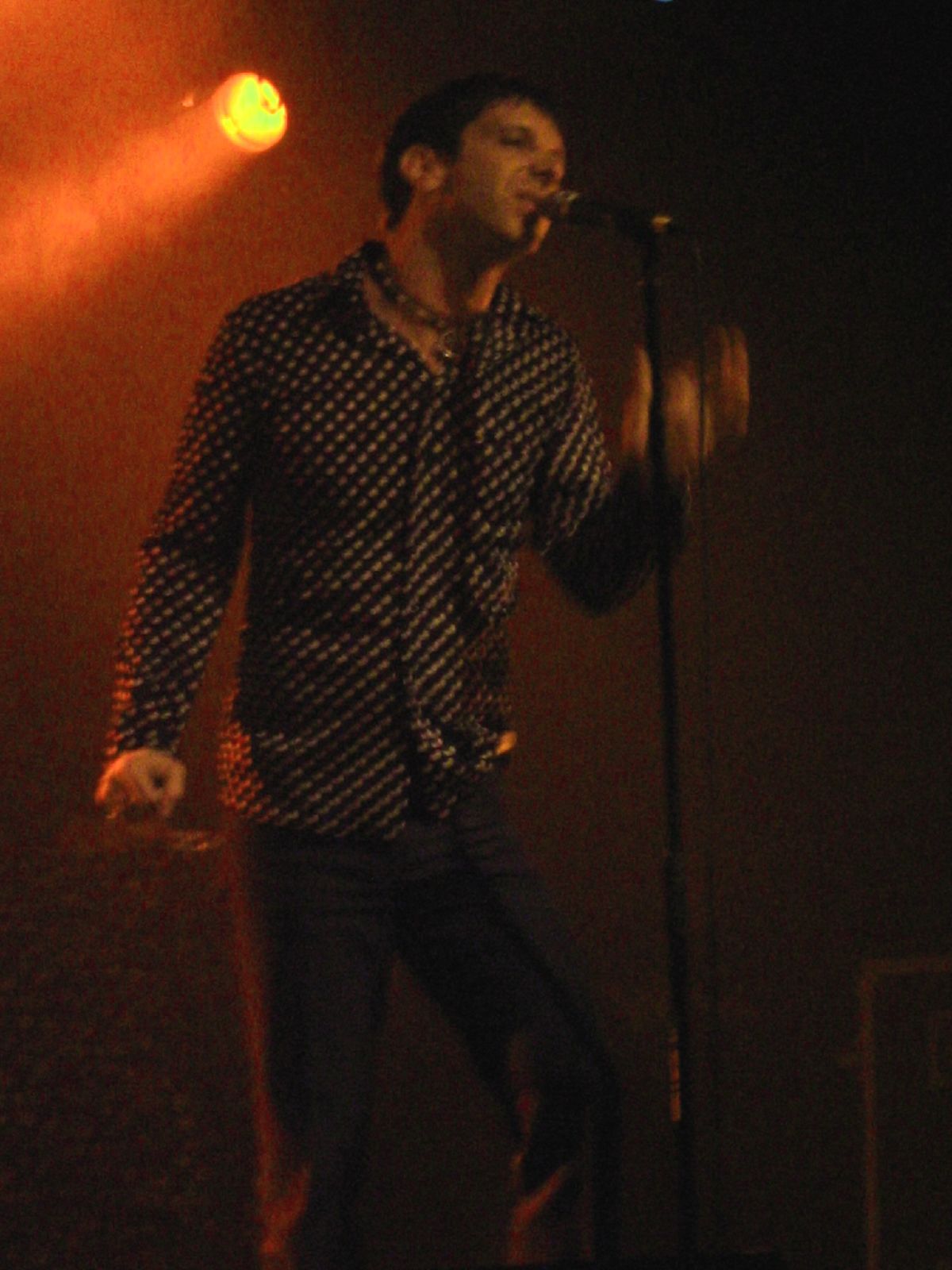 the musician is singing into a microphone on stage