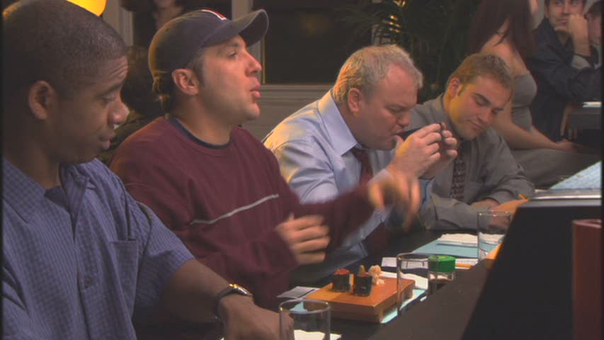 a group of men sit around the table eating food