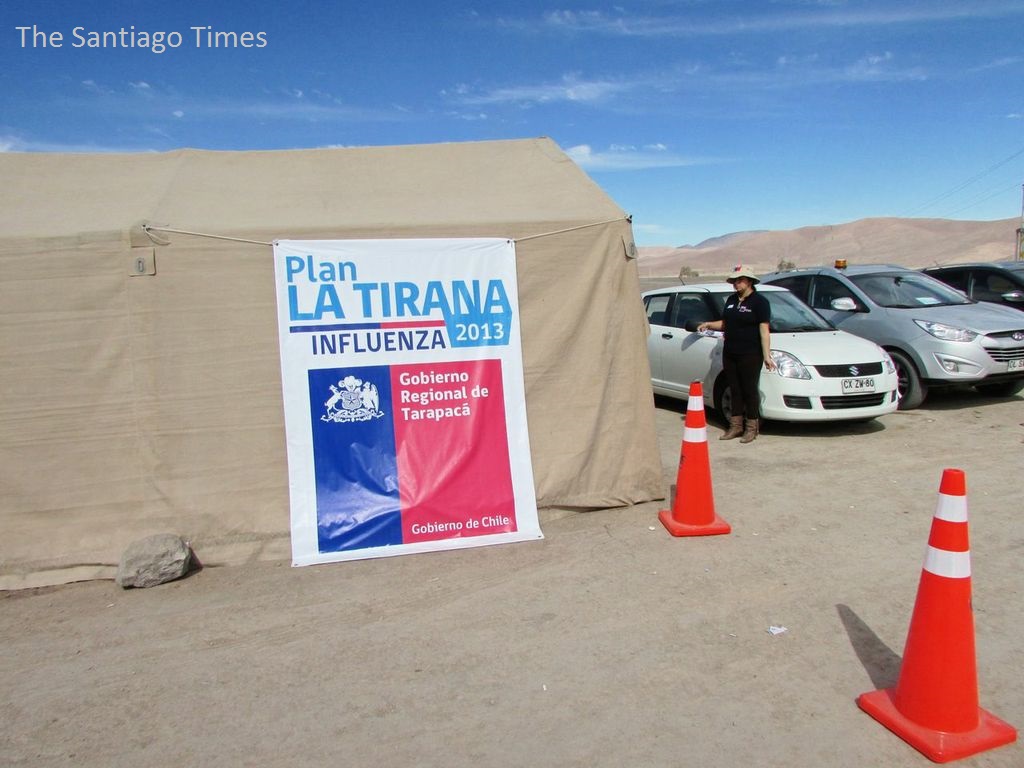 a woman standing in front of two traffic cones near a tent