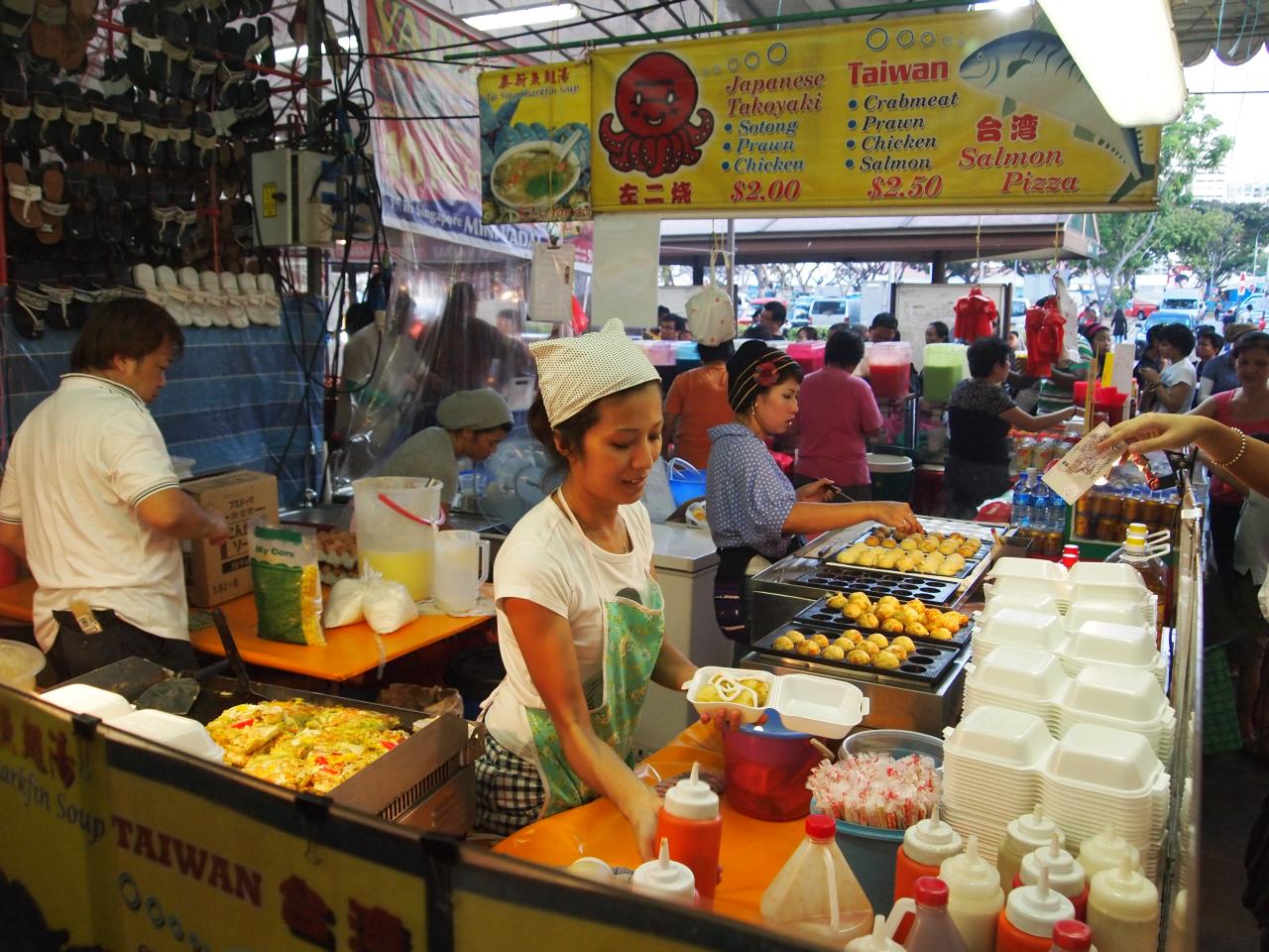 people in a food stand with containers and containers