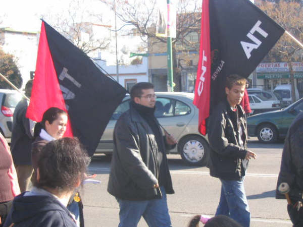 a group of people marching with black and red flags