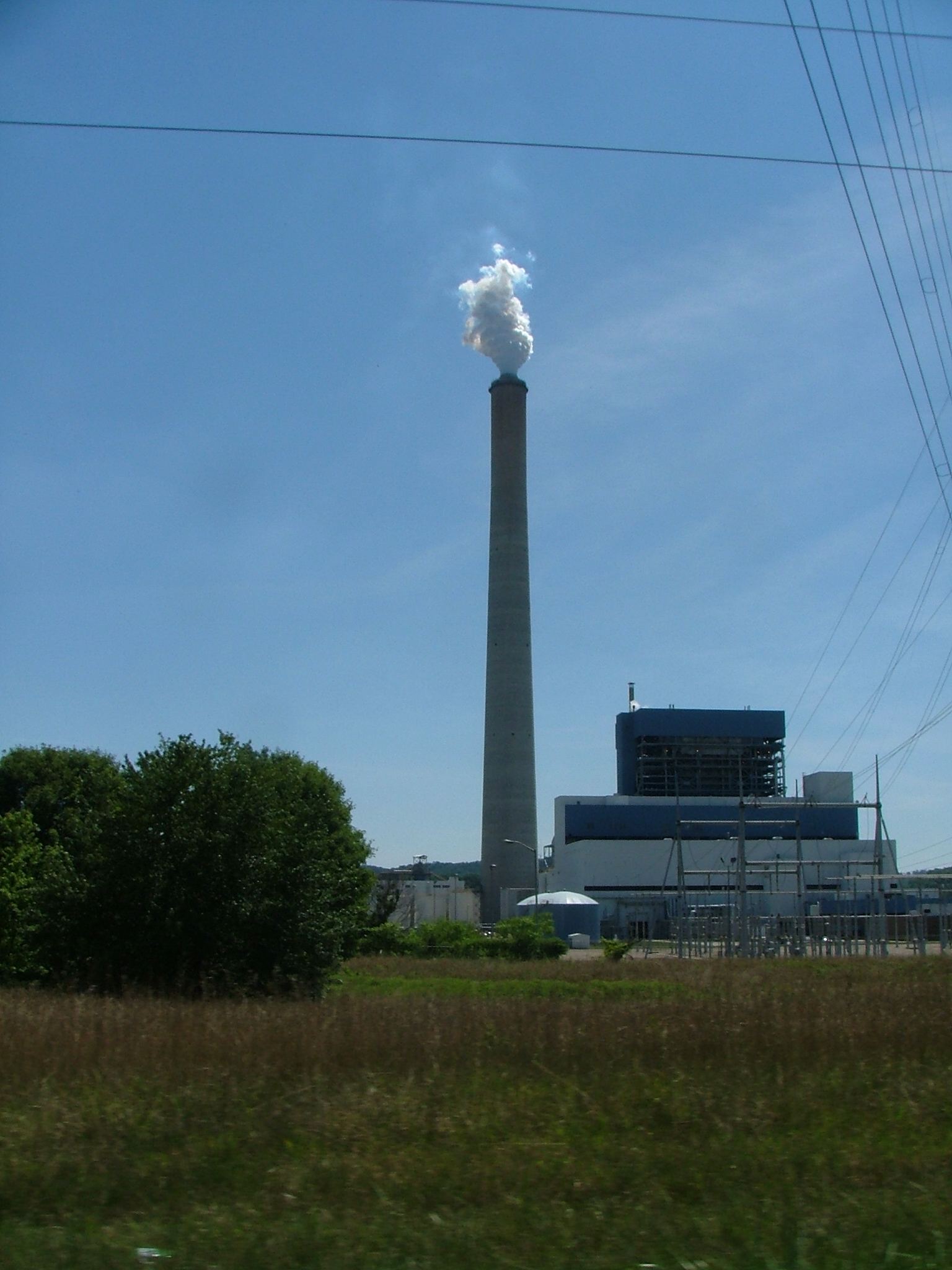 a factory building near a large power plant with smoke stacks