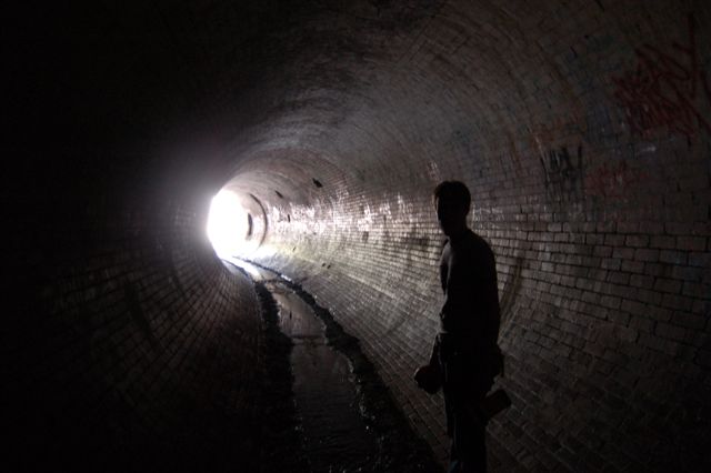 silhouette of a man standing in a dark tunnel
