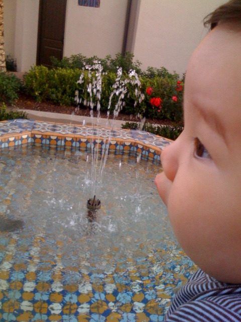 a  with head in fountain looking at soing