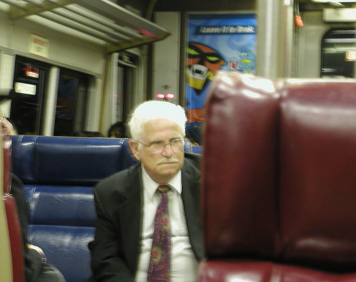 there is an older gentleman sitting on the train