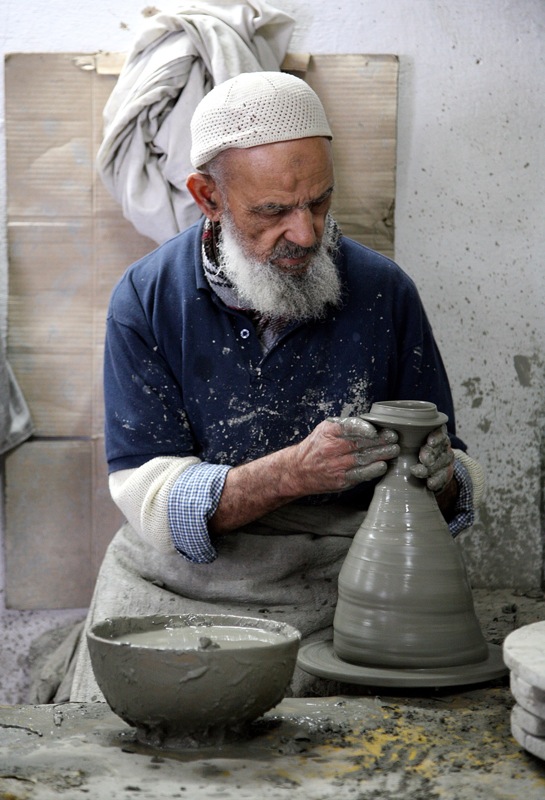 a man making clay bowls in a pottery shop