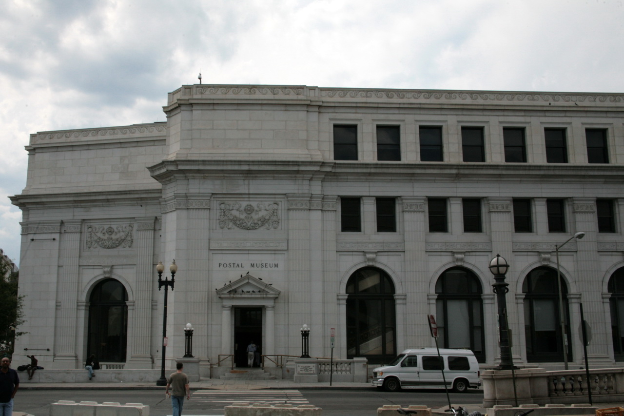 a tall white building with a few people in front of it