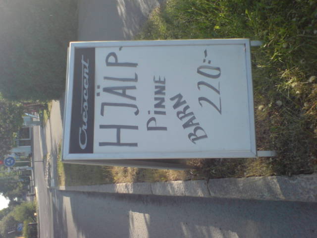 a sign for the hair studio posted on the side of a road