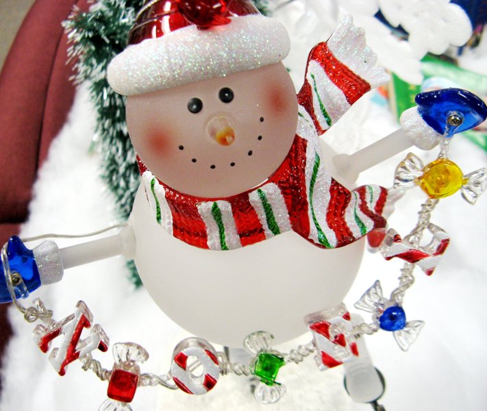 a snowman decoration surrounded by christmas decorations