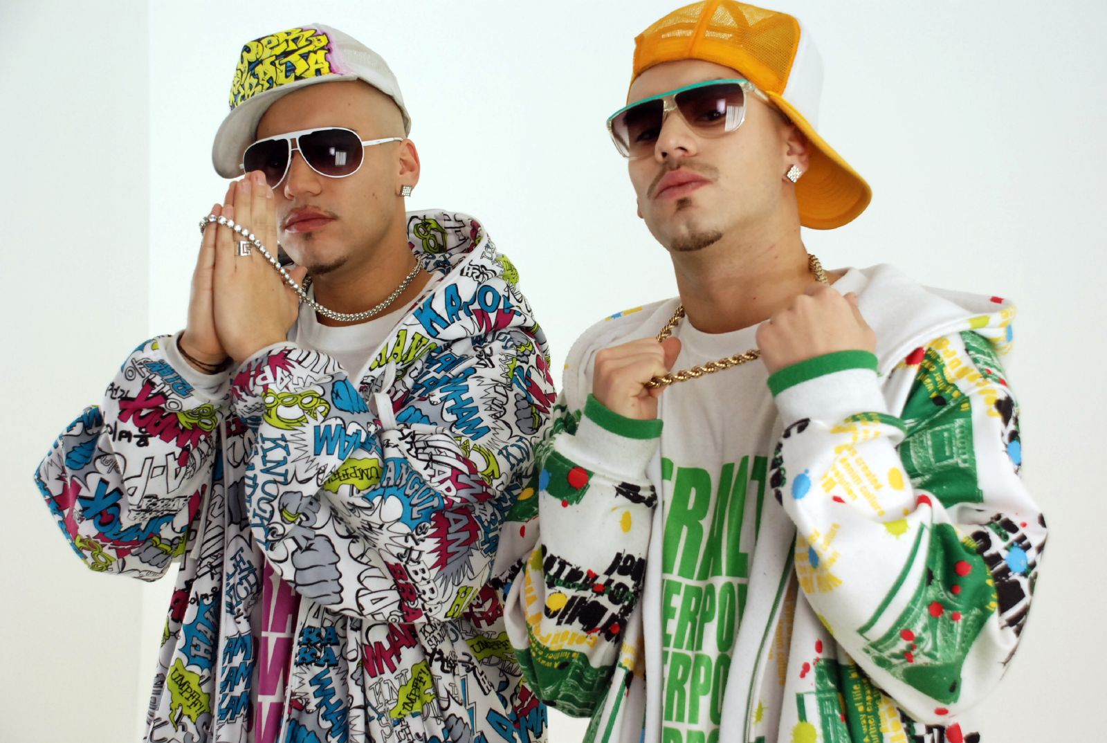 two young men wearing colorful clothes pose for the camera