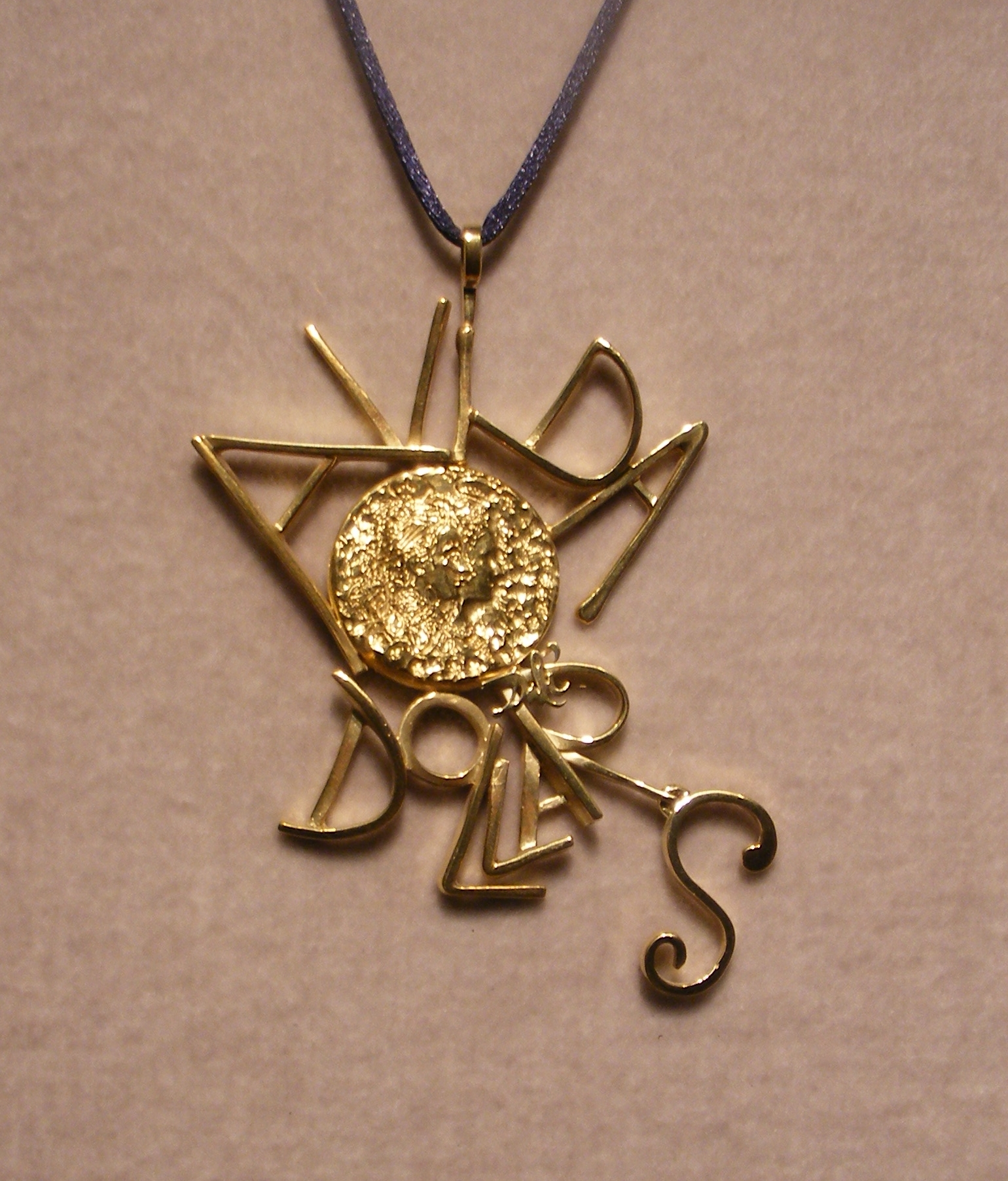 an ornate bronze pendant has an ornament hanging from it