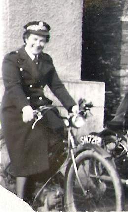 a old fashioned po of a woman sitting on top of an antique bicycle