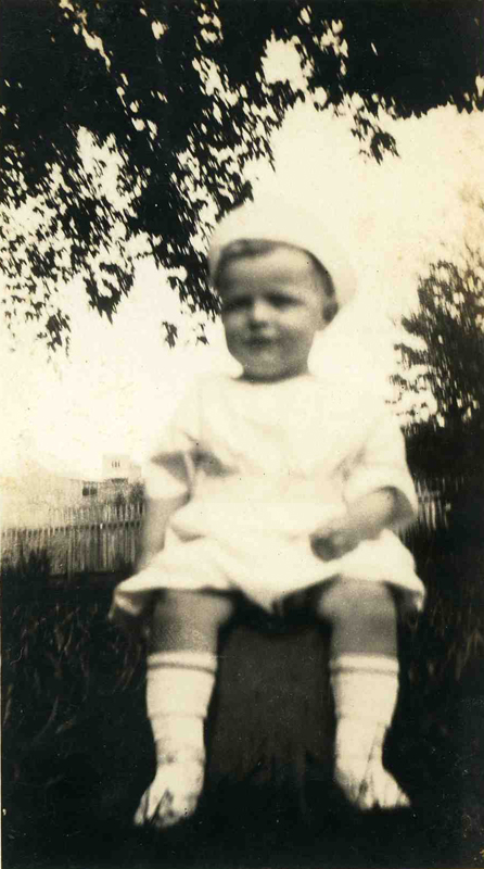 an old po of a baby girl sitting on top of a table