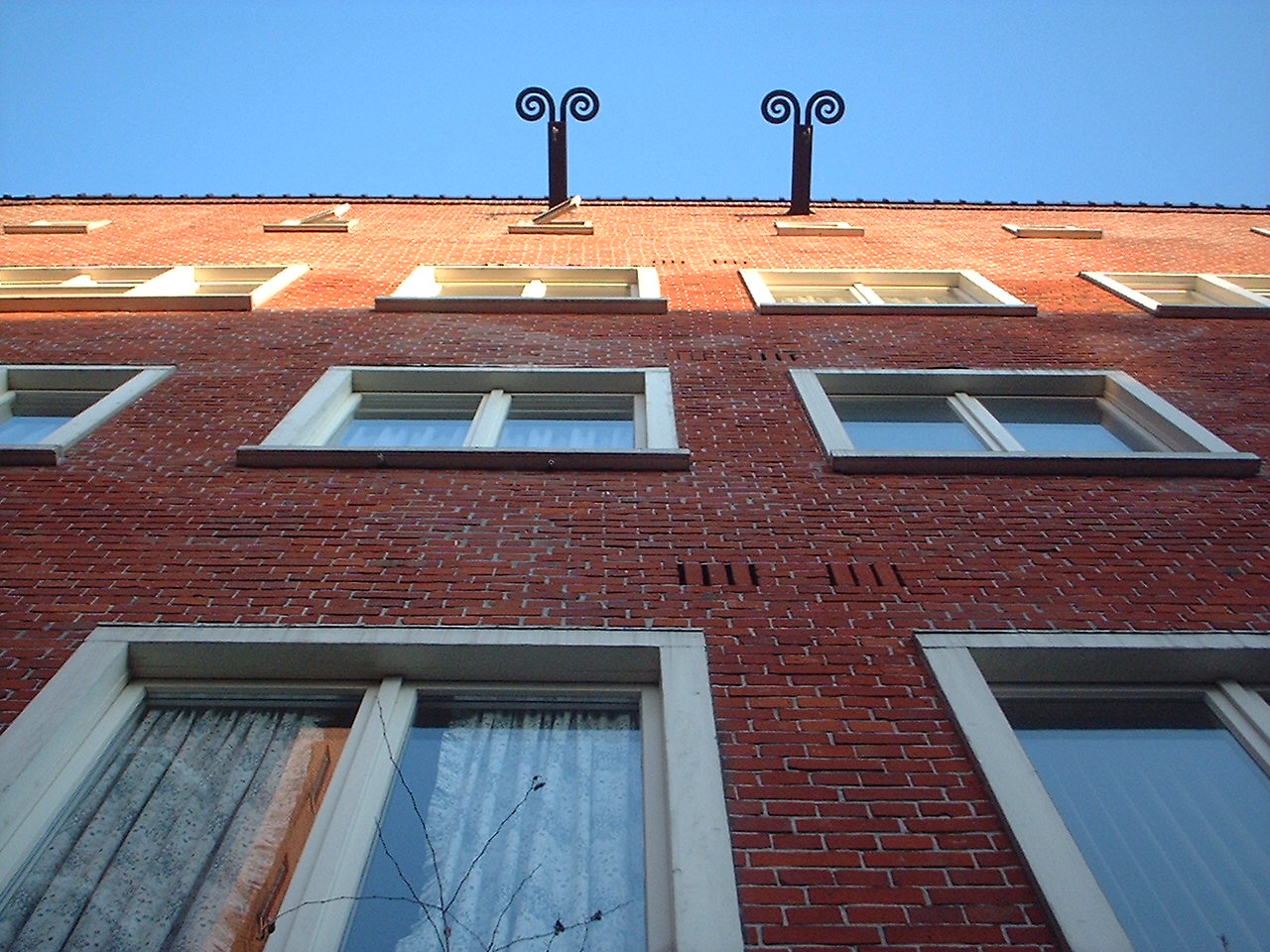 two large windows on top of a brick building