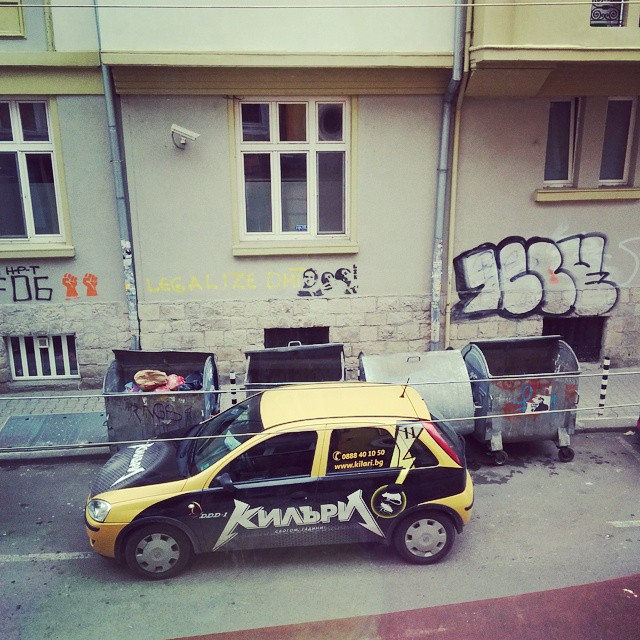 a small taxi is parked in front of the street