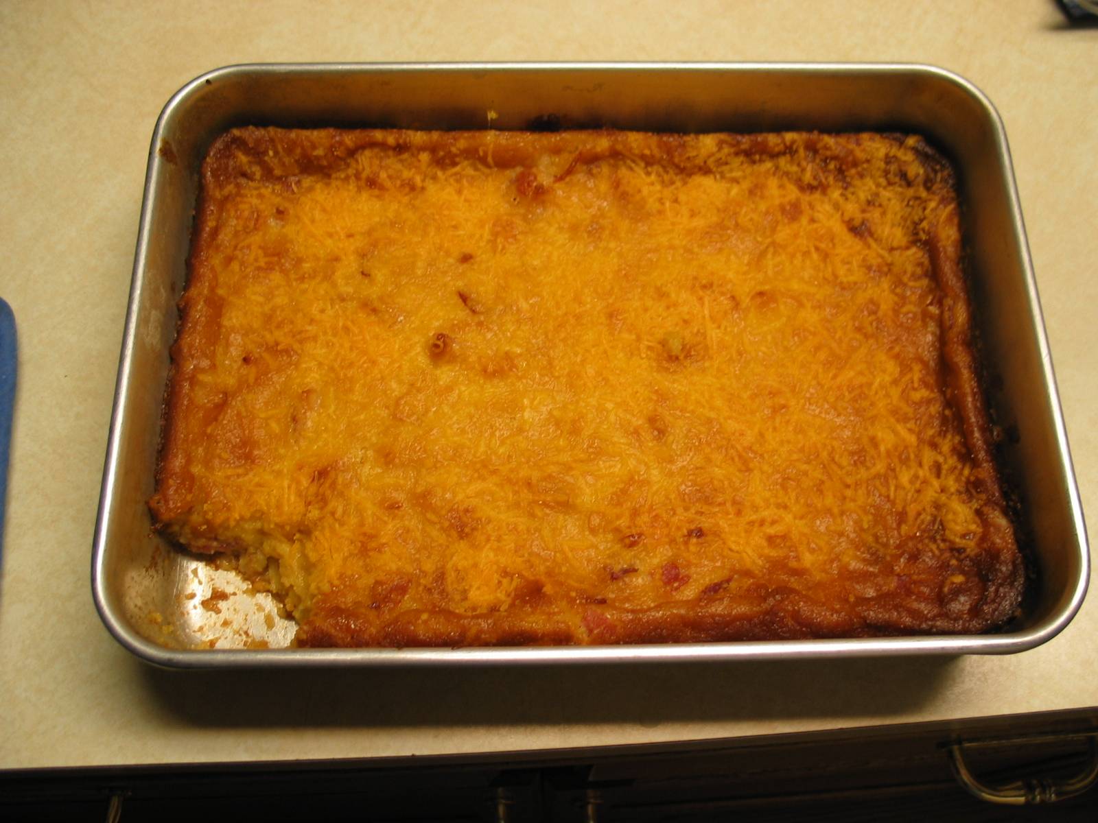 a casserole with cheese and other toppings sits in a baking pan