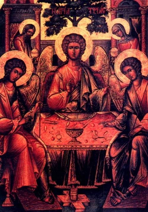 two women and a man sitting at a table surrounded by angels