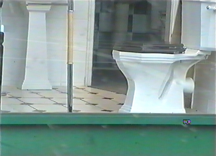a toilet sits on display outside of a window