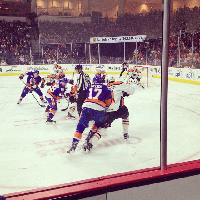 hockey players playing on the ice while fans watch