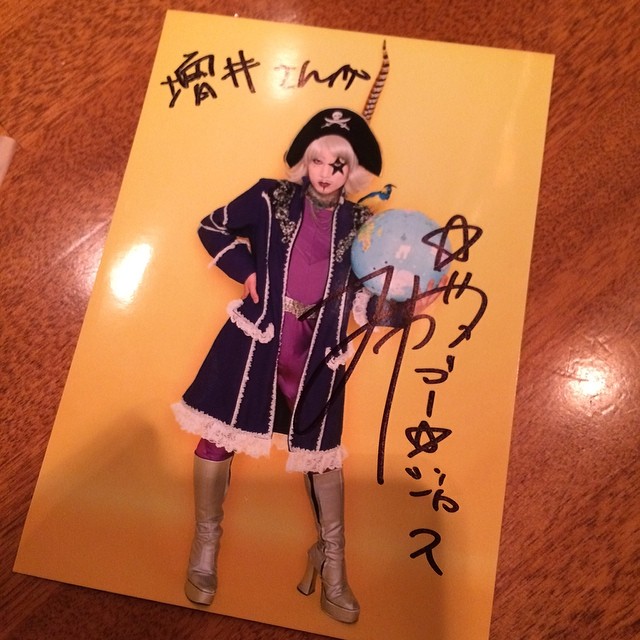 the doll is wearing a purple outfit and standing in front of a card